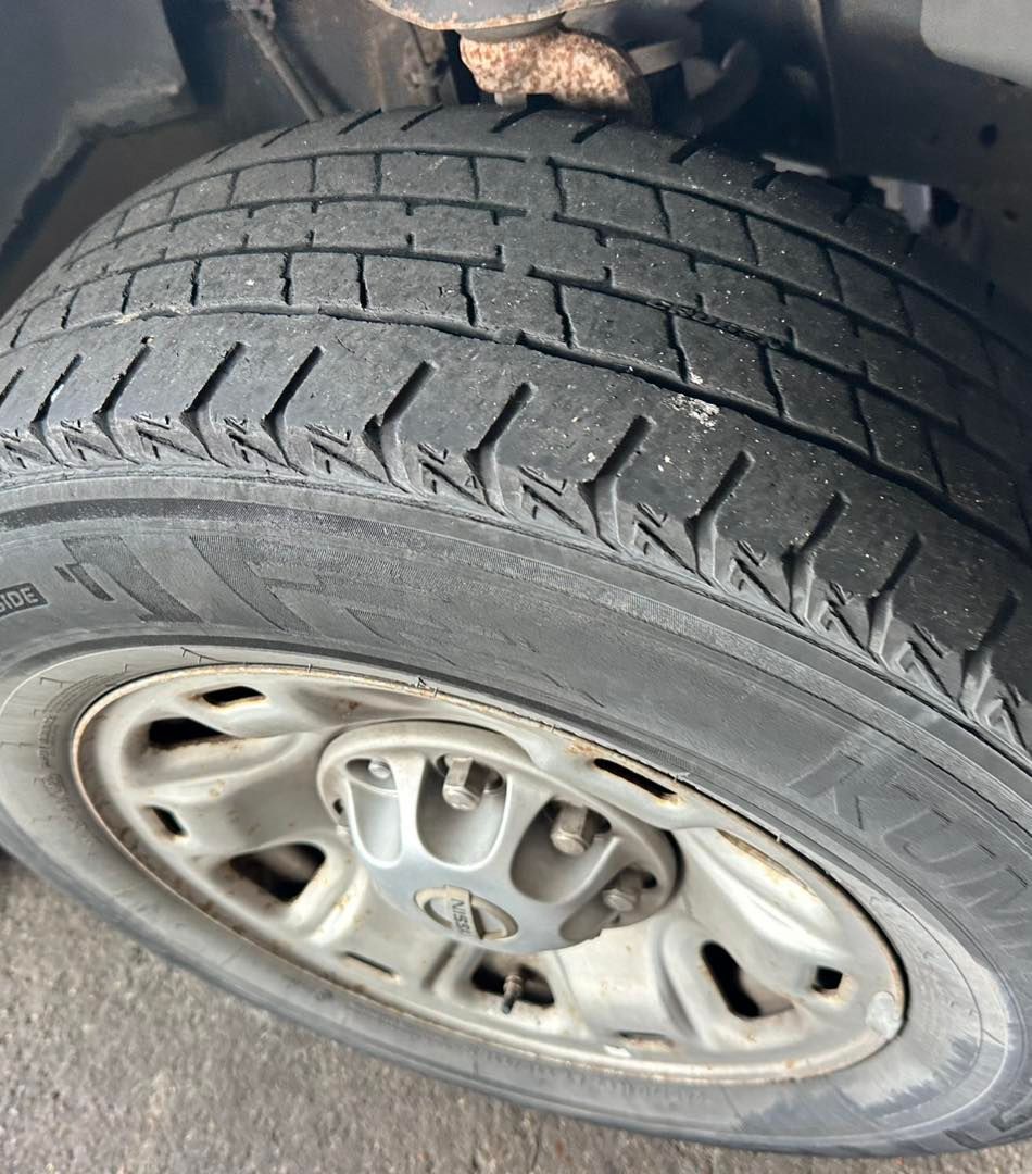Close-up of a worn tire on a silver car wheel.