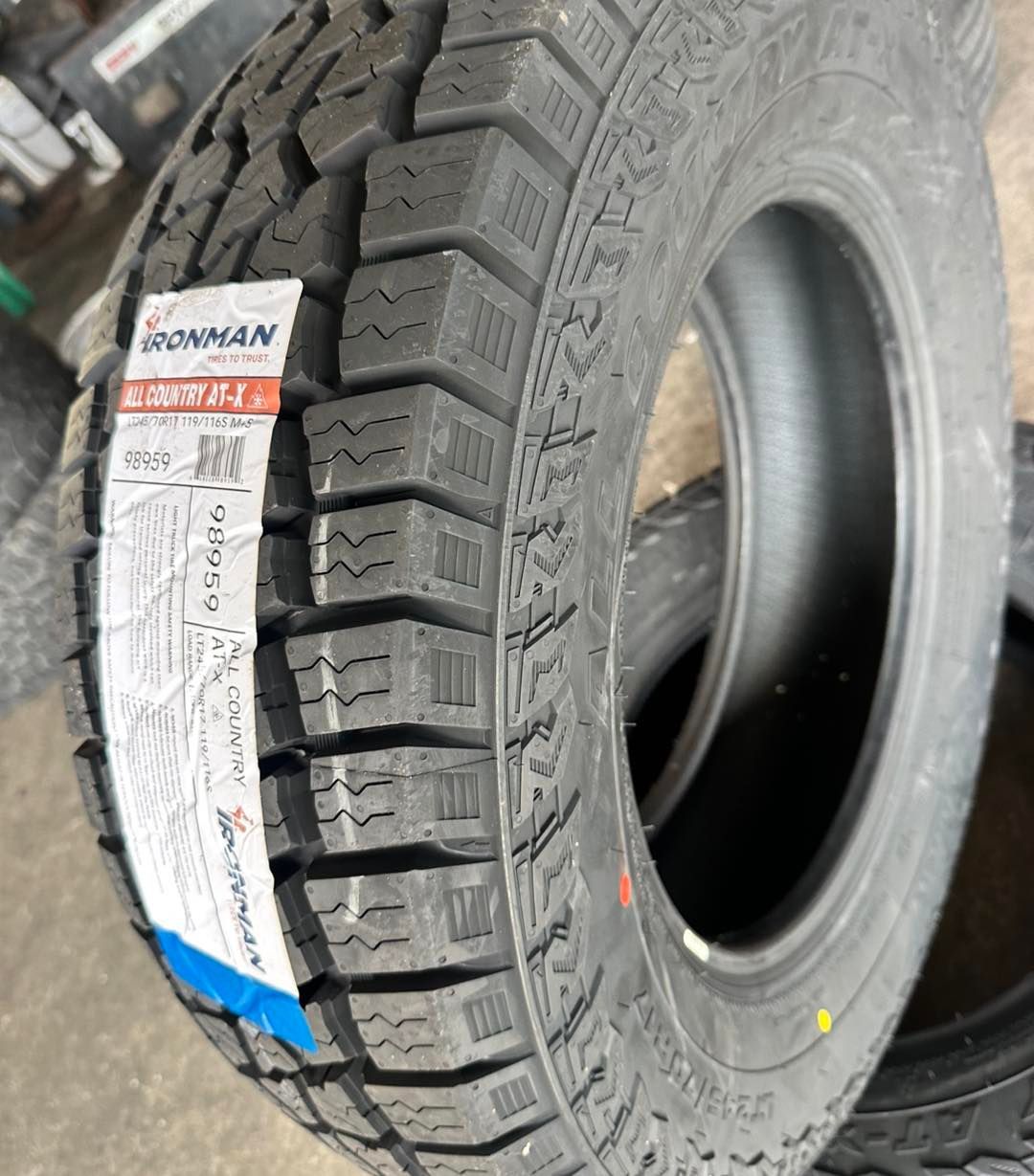 New Ironman tire with thick tread and attached label.