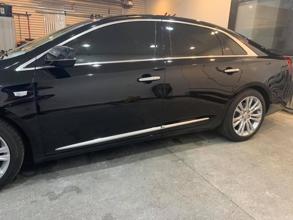 A black car is parked in a garage.