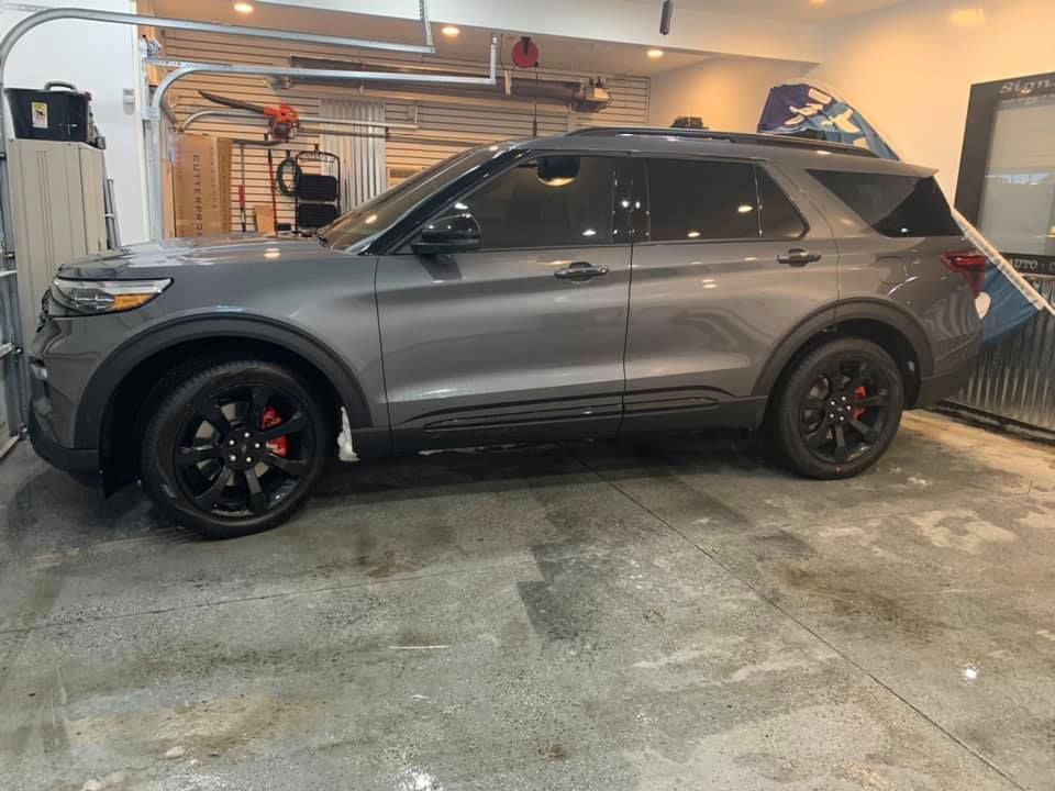 A gray ford explorer is parked in a garage.