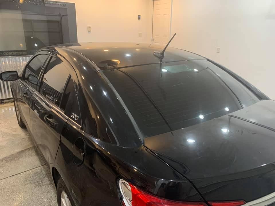 A black car is parked in a garage.