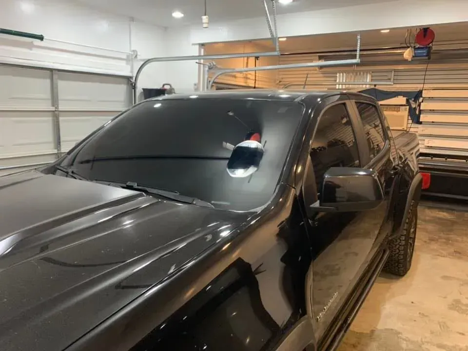 A black truck is parked in a garage.