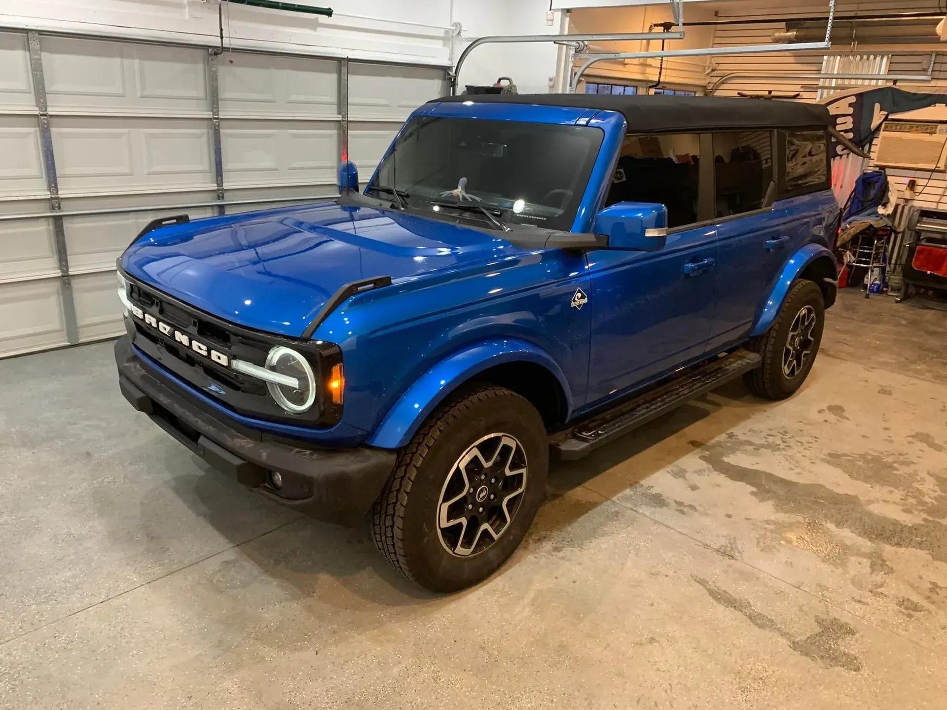 A blue ford bronco is parked in a garage.
