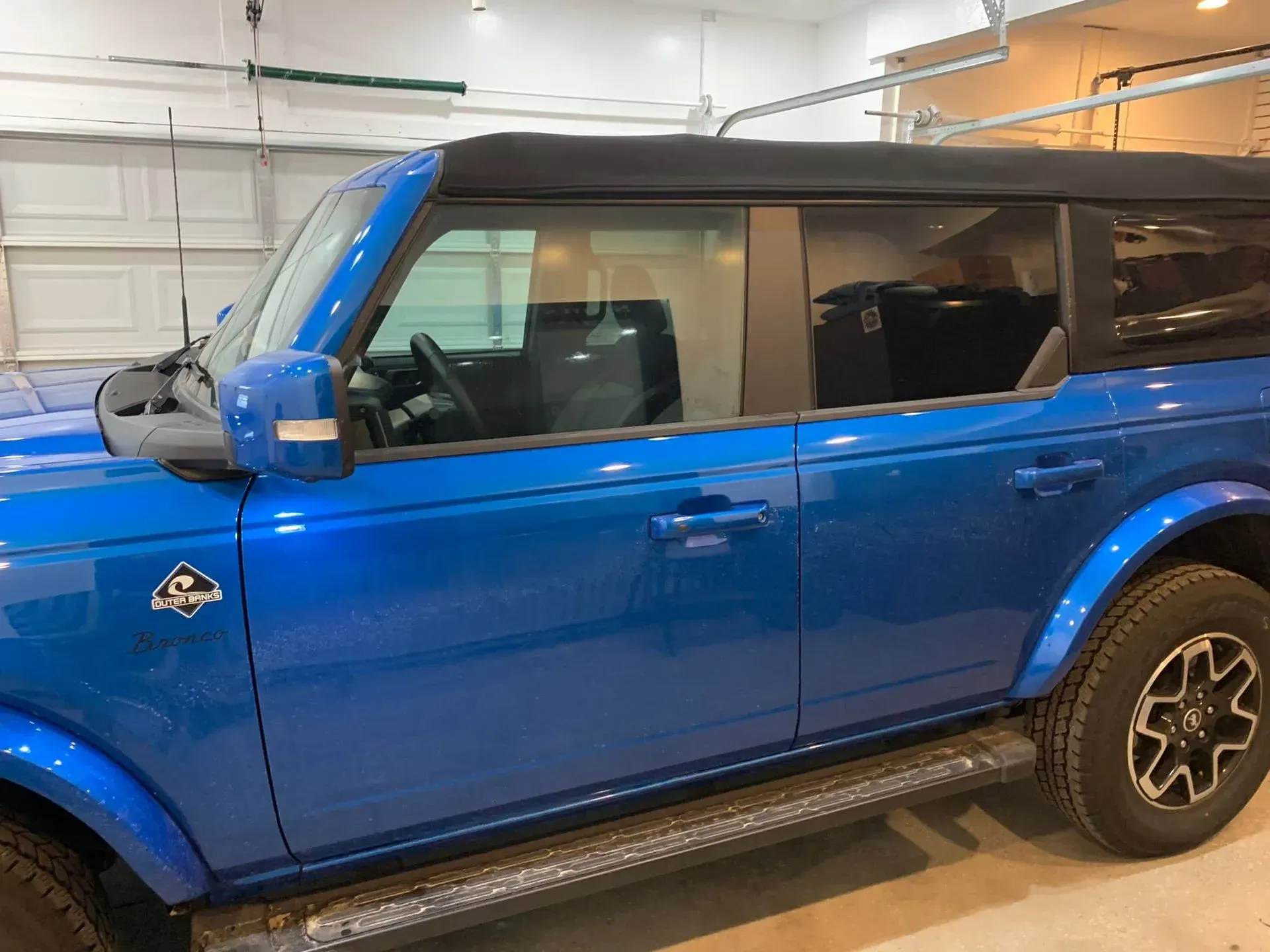 A blue ford bronco is parked in a garage.