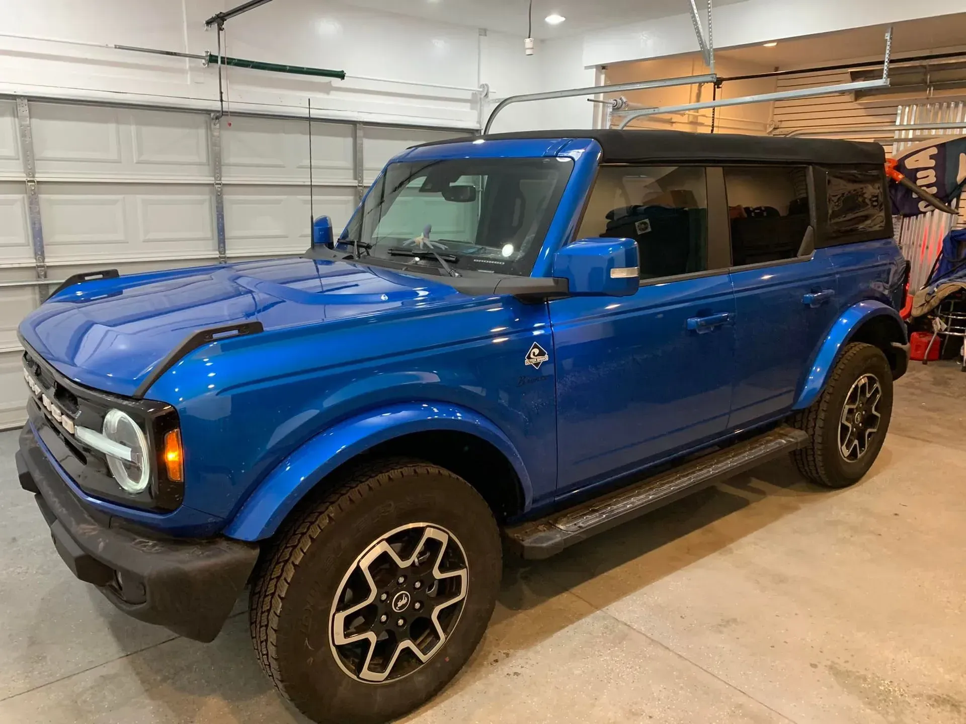 A blue ford bronco is parked in a garage.