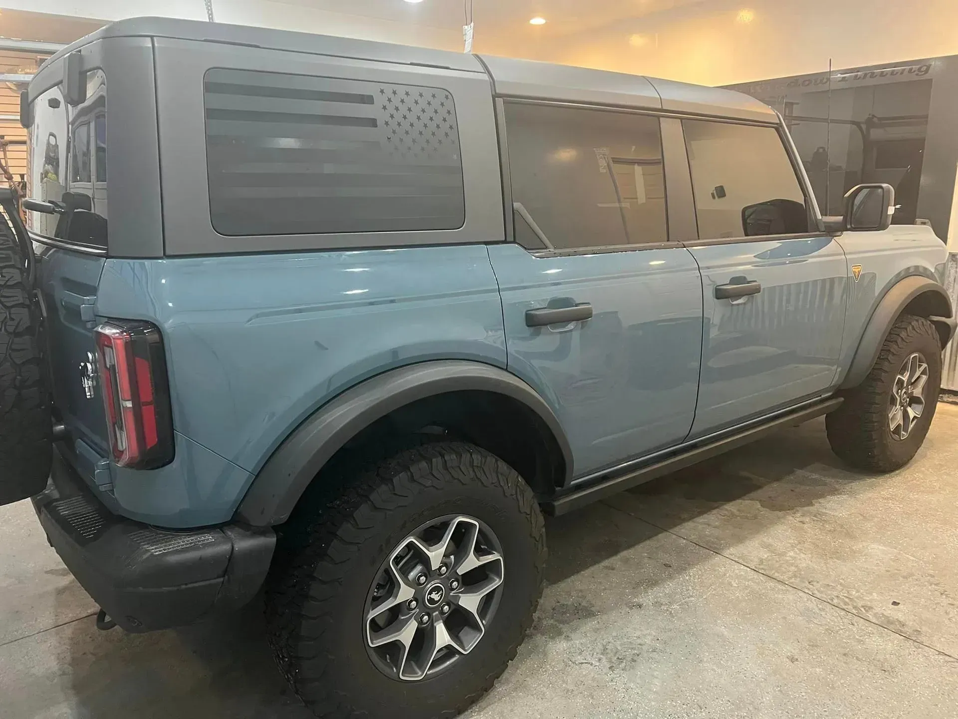 A blue ford bronco is parked in a garage.