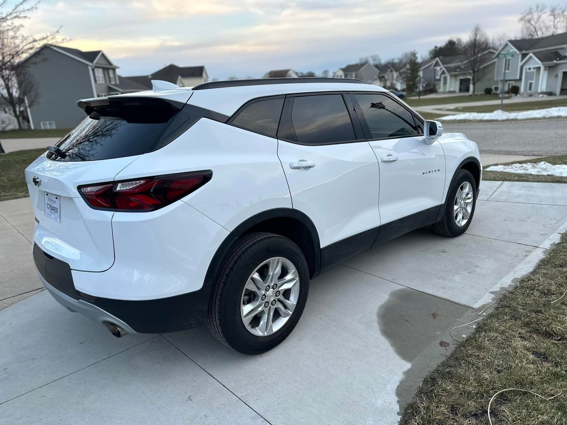 A white chevrolet blazer is parked in a driveway.