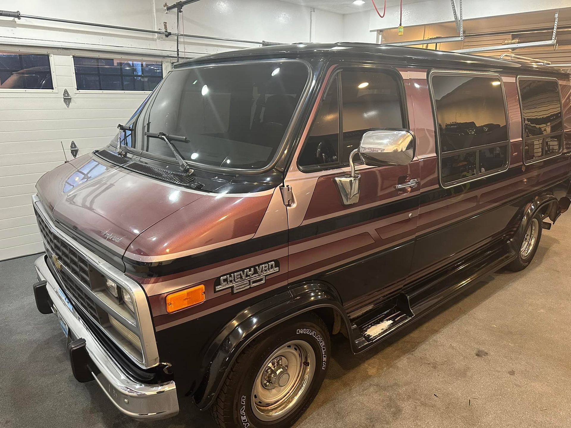 A purple and black van is parked in a garage.
