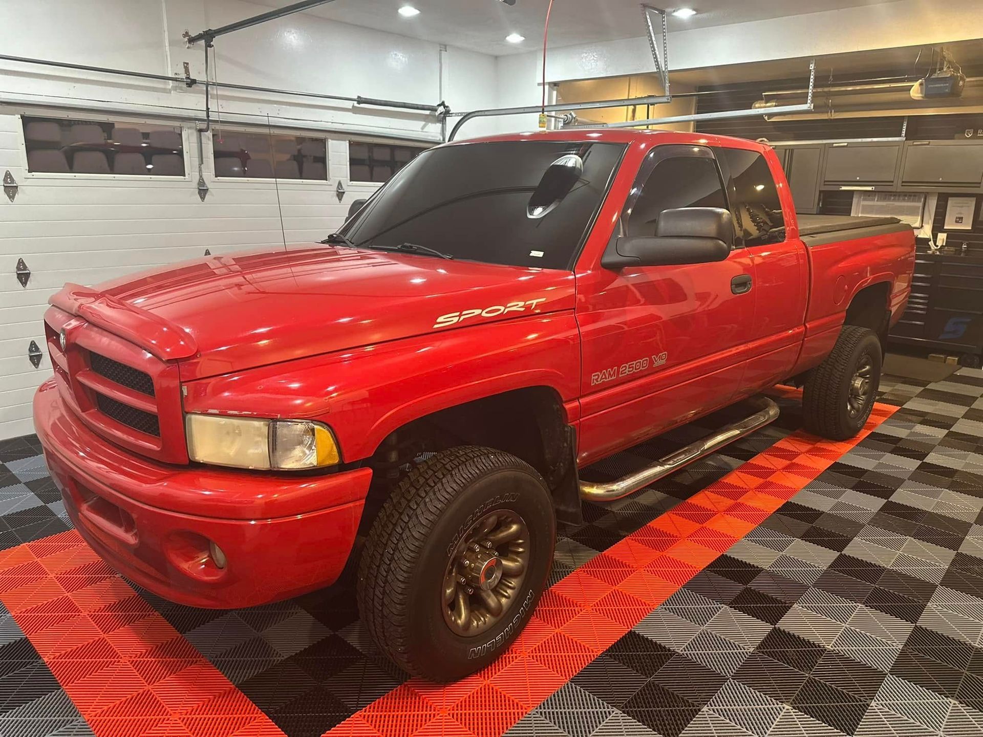 A red dodge ram truck is parked in a garage.