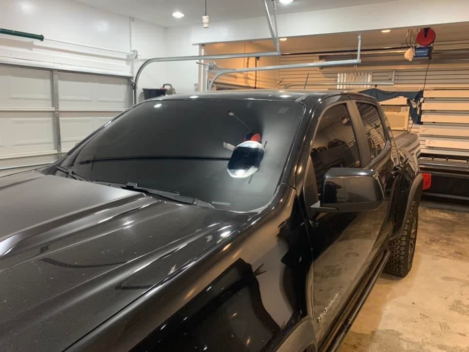 A black truck is parked in a garage.