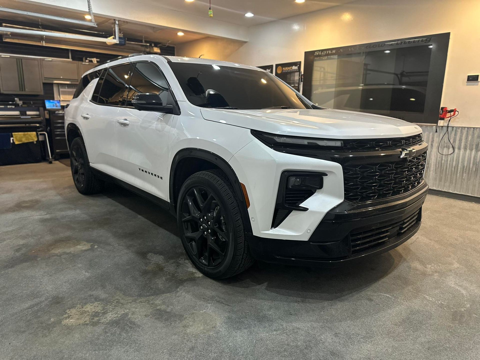 A white chevrolet trailblazer is parked in a garage.