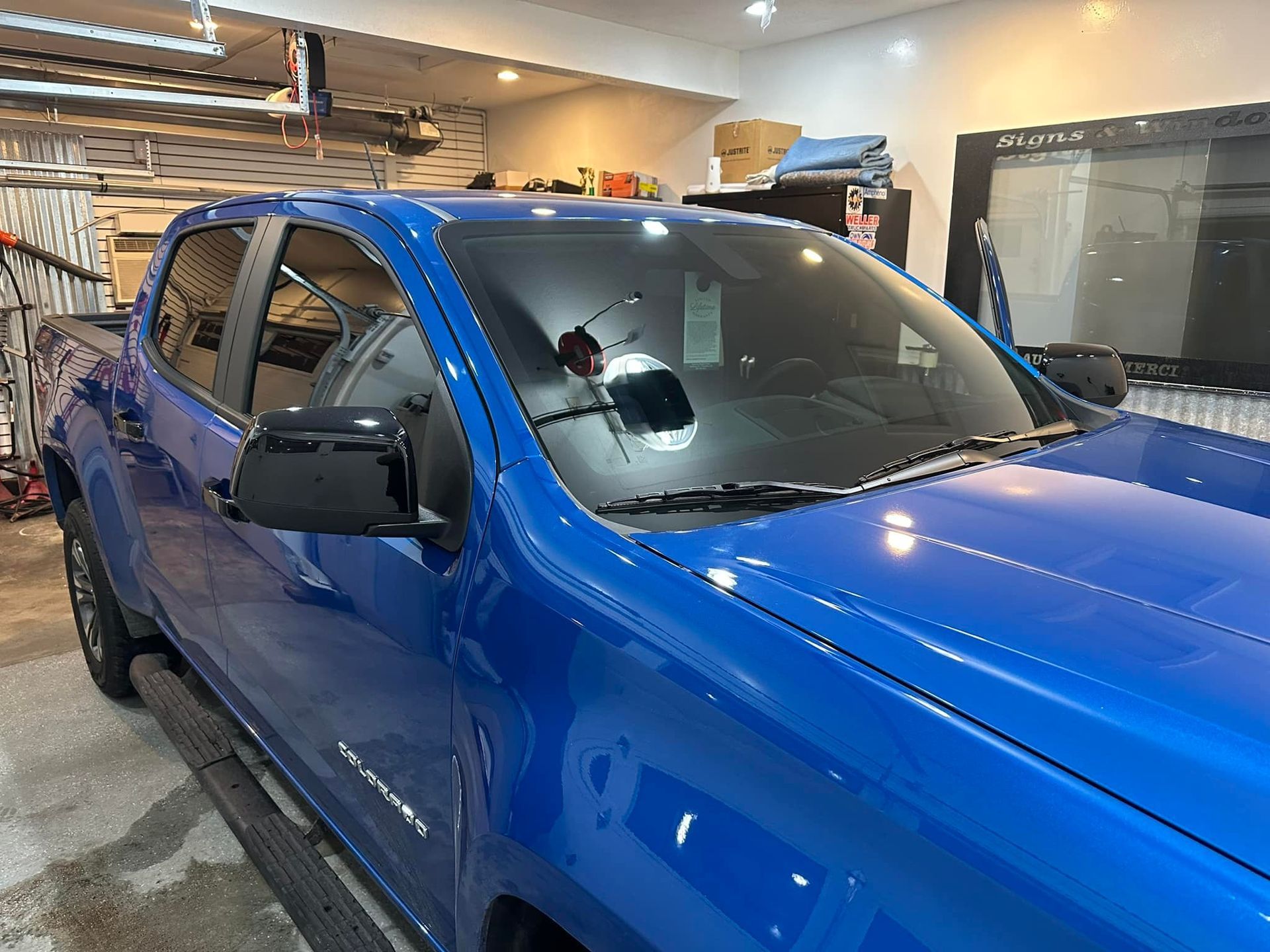 A blue truck is parked in a garage.