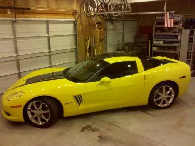 A yellow sports car is parked in a garage