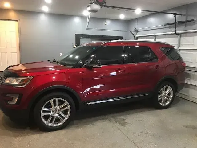 A red ford explorer is parked in a garage.