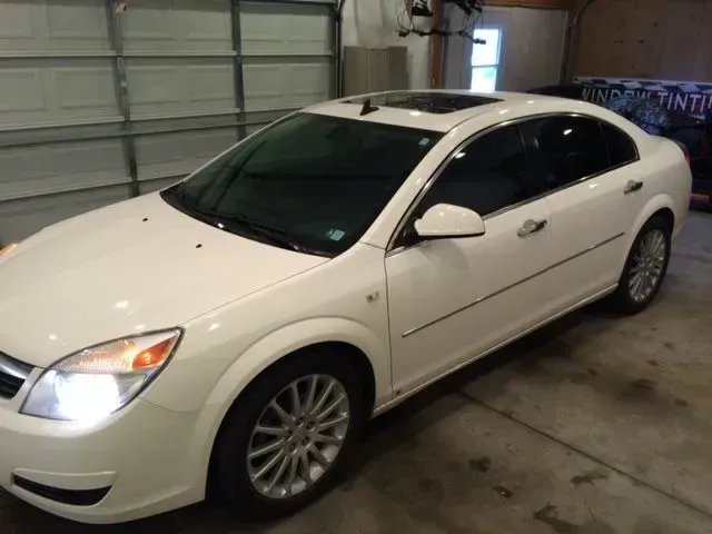 A white car is parked in a garage next to a garage door