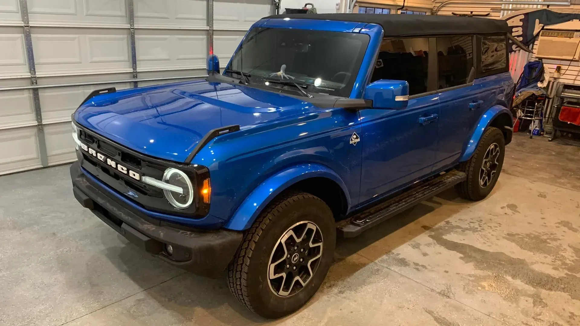A blue ford bronco is parked in a garage.