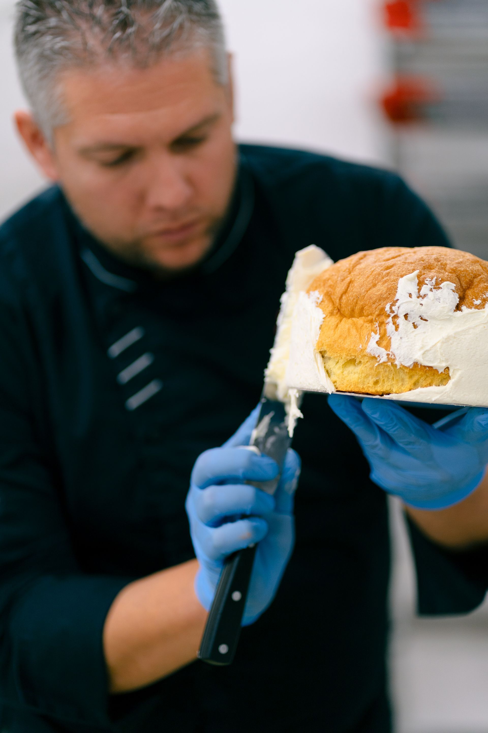 pasticcere cosparge di panna un panettone artigianale a Torino