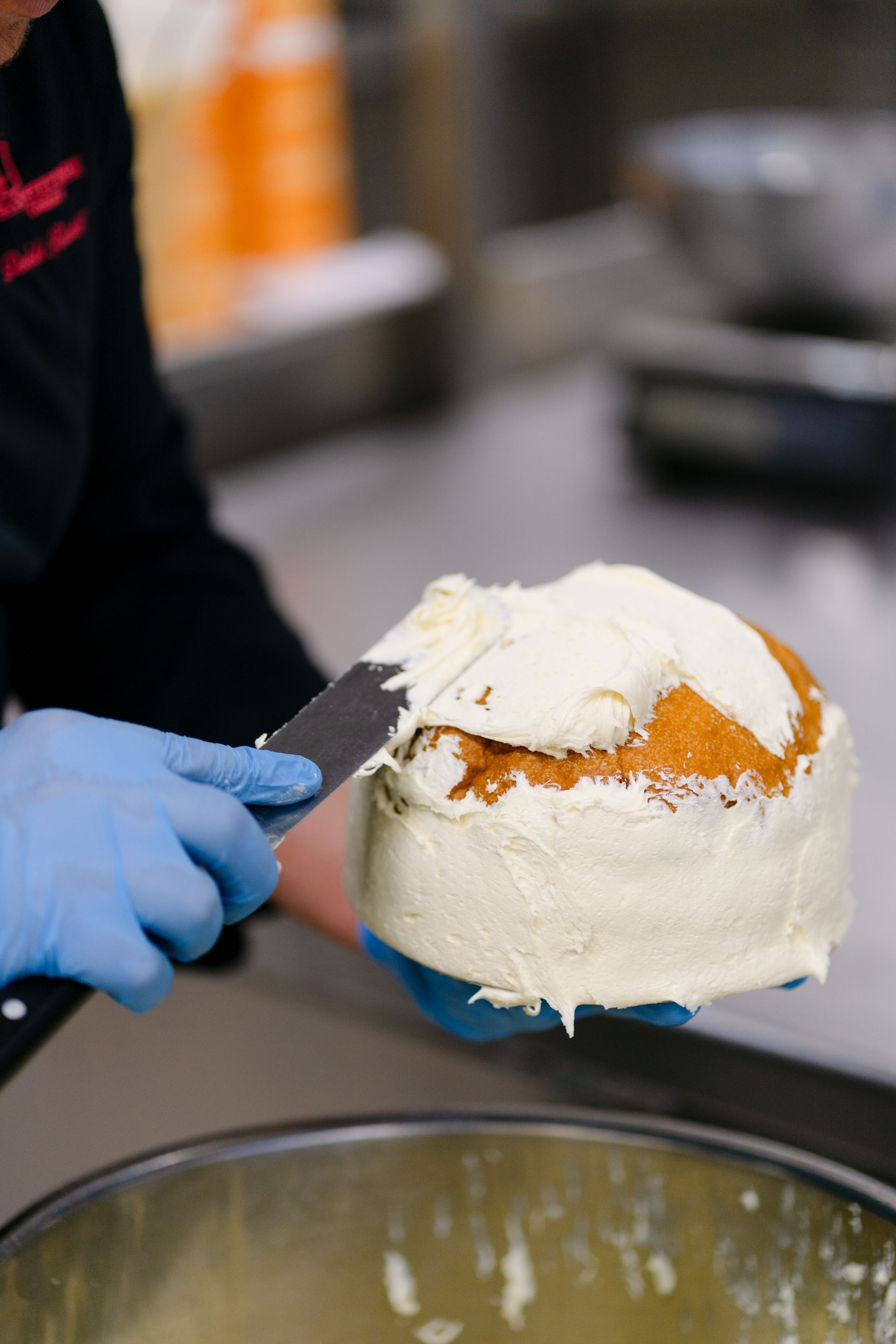 pasticcere cosparge di panna un panettone artigianale a Torino