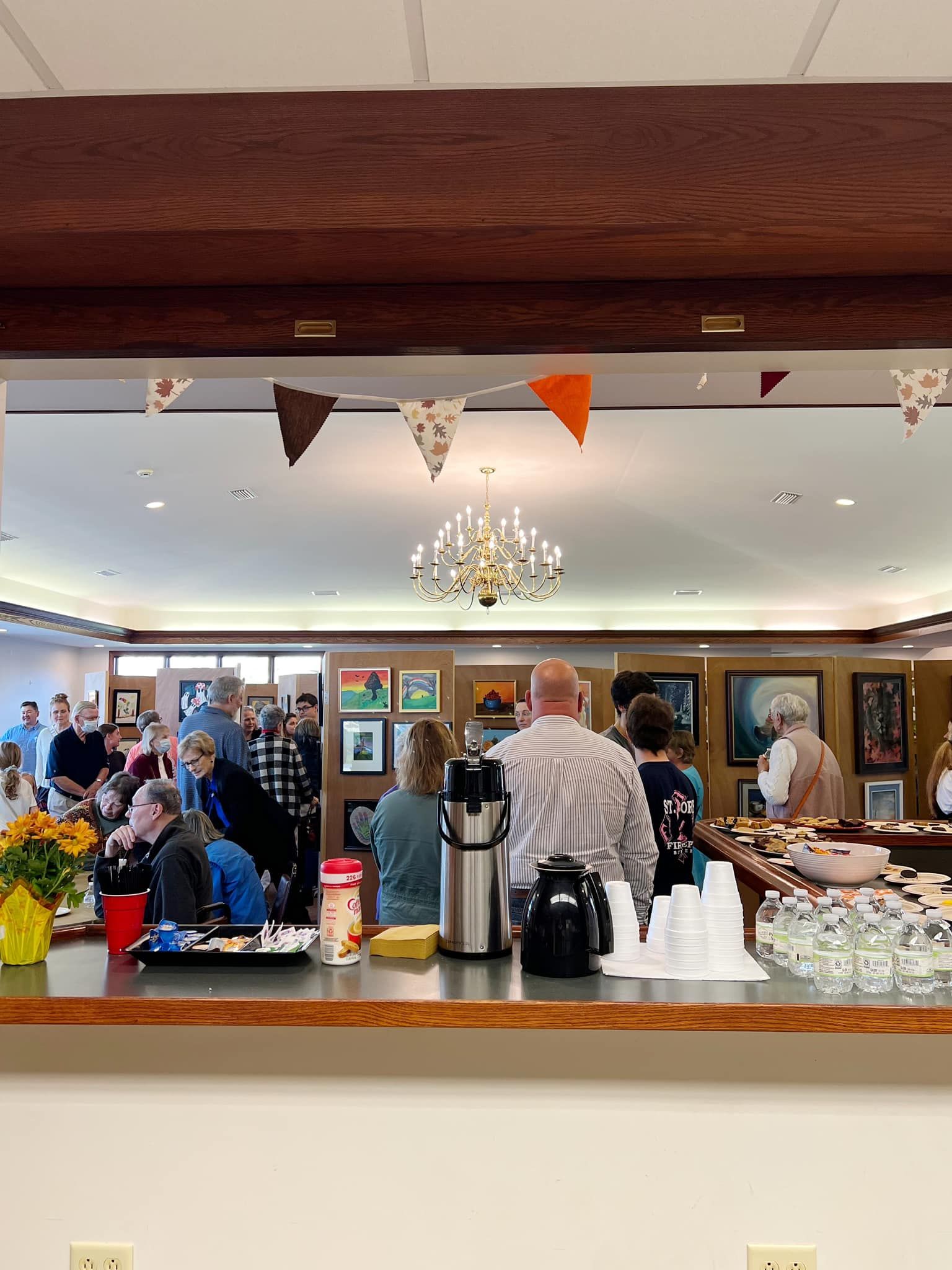 A group of people are gathered in a room behind a counter.