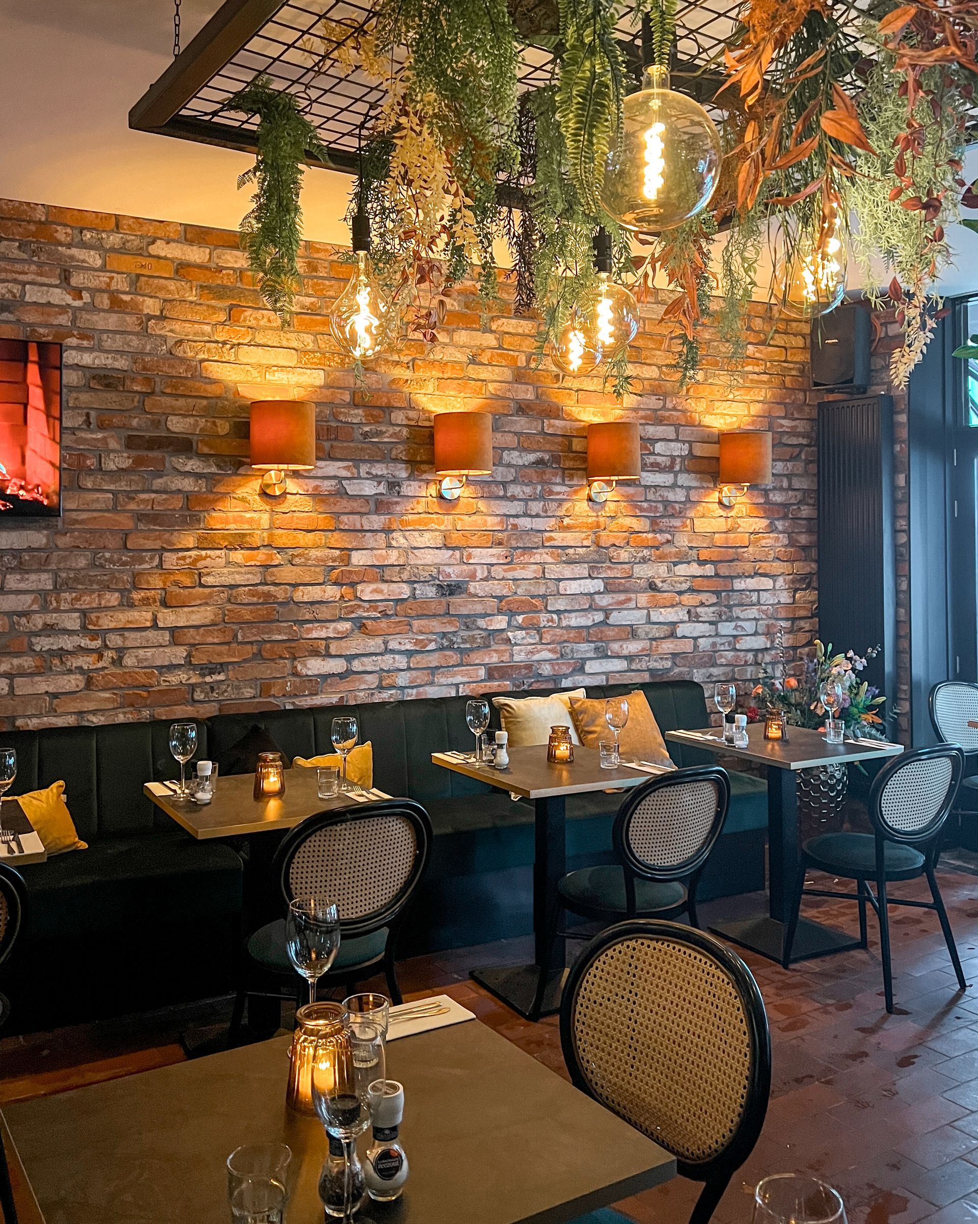 Een restaurant met tafels en stoelen en een bakstenen muur.
