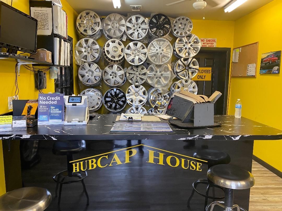 Interior of Hubcap House store, yellow walls, wheels on display behind the counter, and seating.