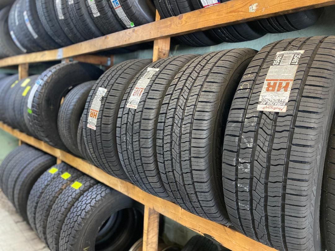 Tires stacked on wooden shelves, possibly in a tire shop.