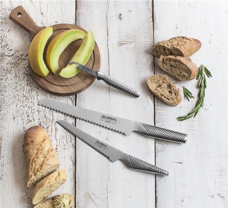 Een houten snijplank met meloen en brood erop