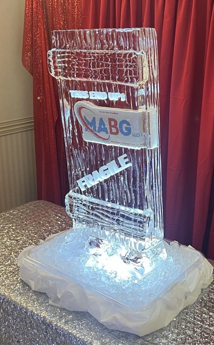 A group of people are sitting around a table with laptops.