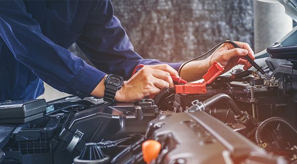 A mechanic is working on a car in a garage.