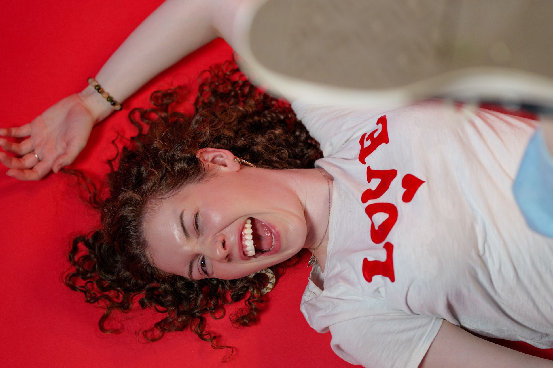 A person with curly hair wearing a white 