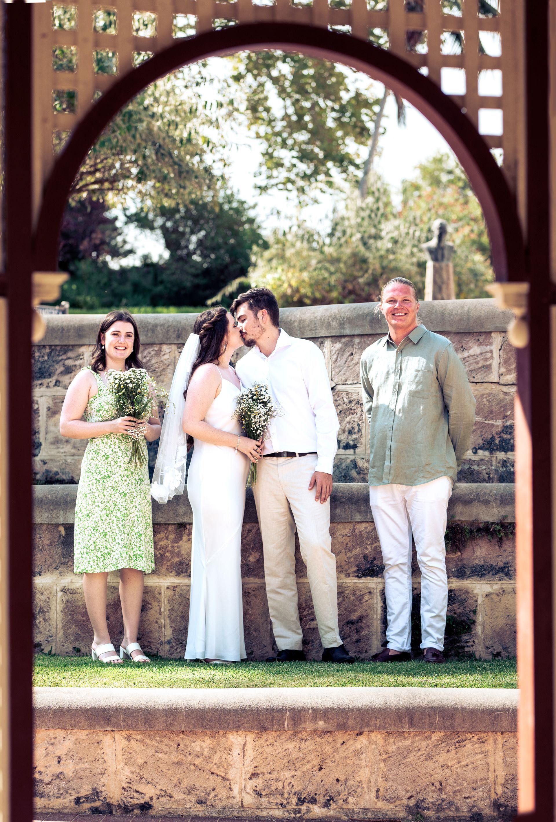 A bride and groom are posing for a picture with their wedding party.