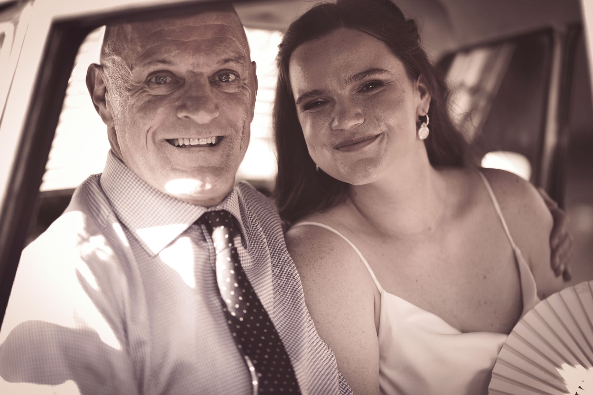 A man and a woman are posing for a picture in a car