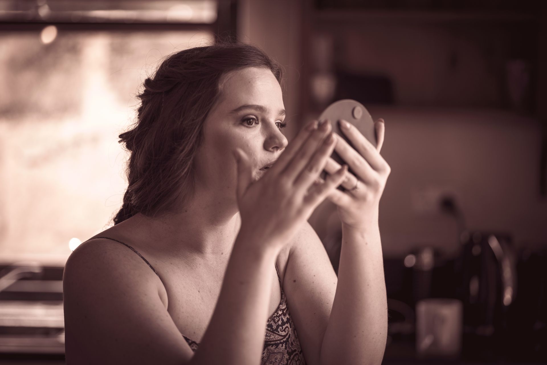 A woman is looking at herself in a mirror.