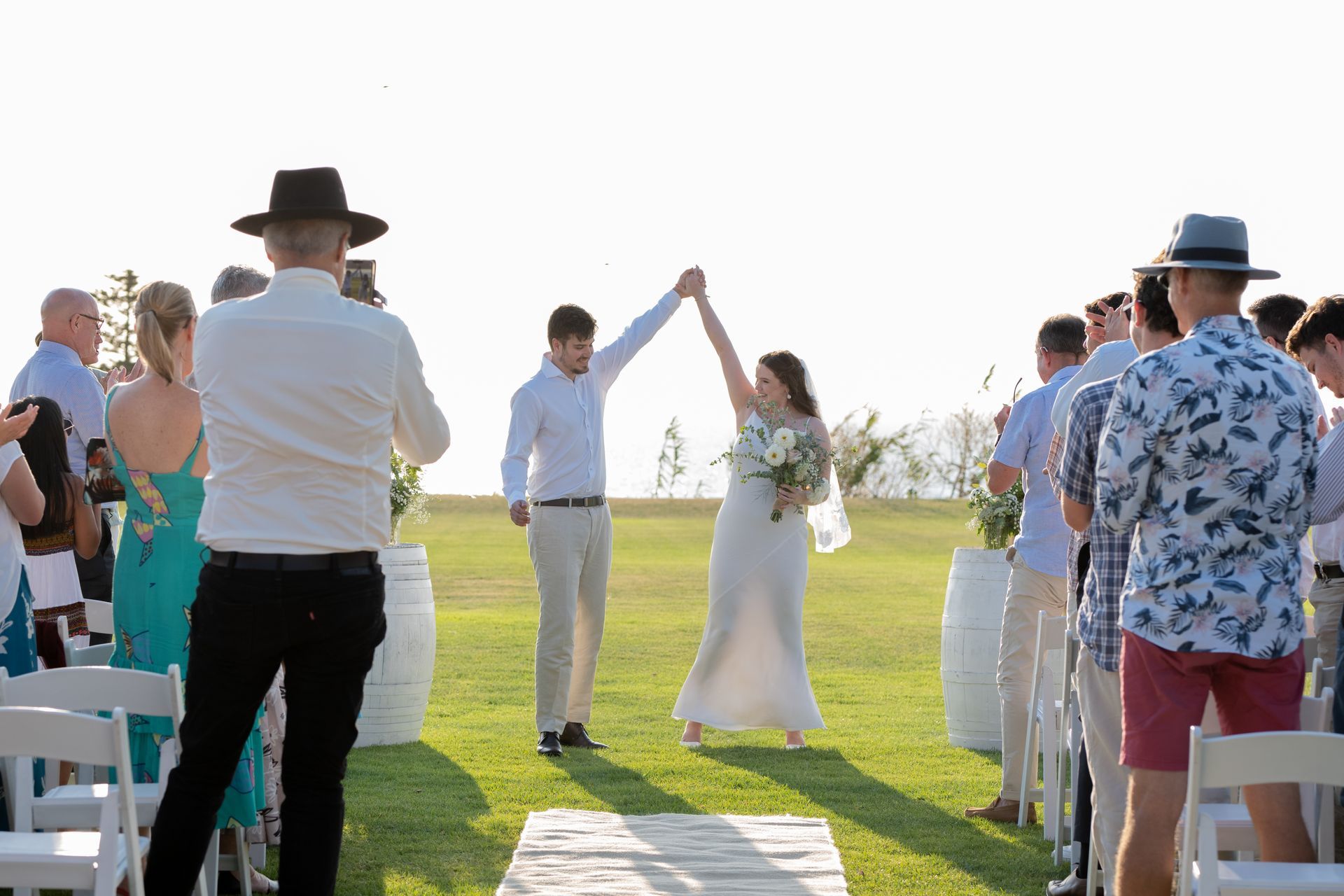 A bride and groom are holding hands at their wedding ceremony.