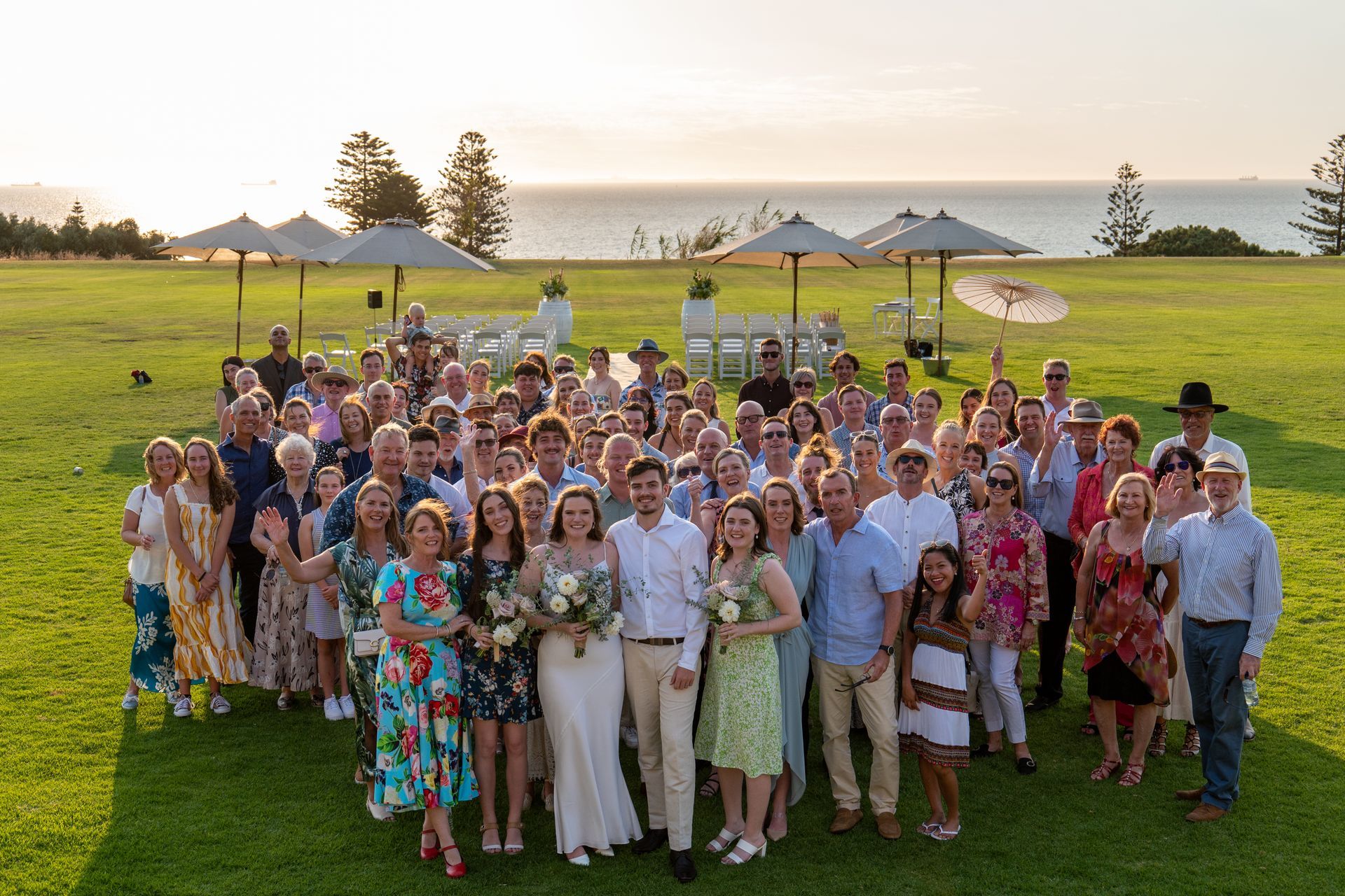A large group of people are posing for a picture in a grassy field.