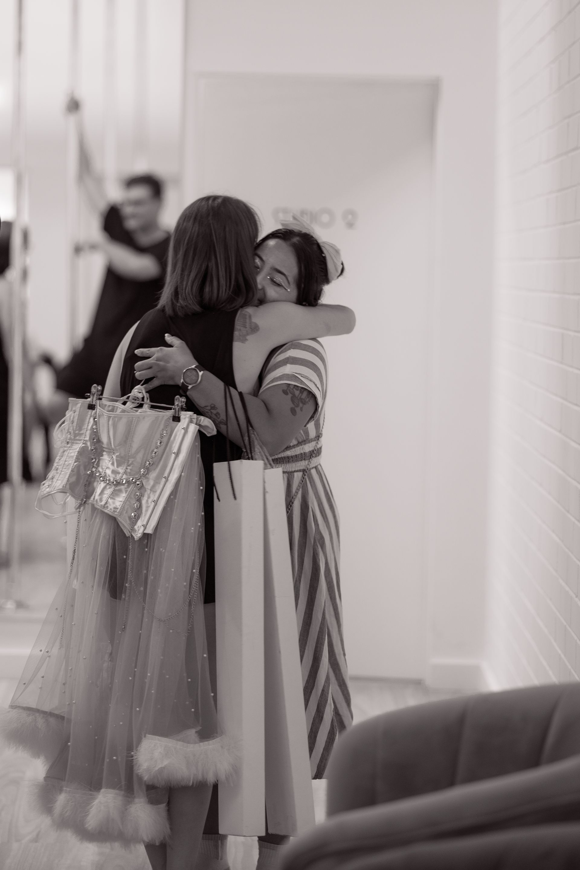 A woman is kneeling down in a dance studio holding a red flag.