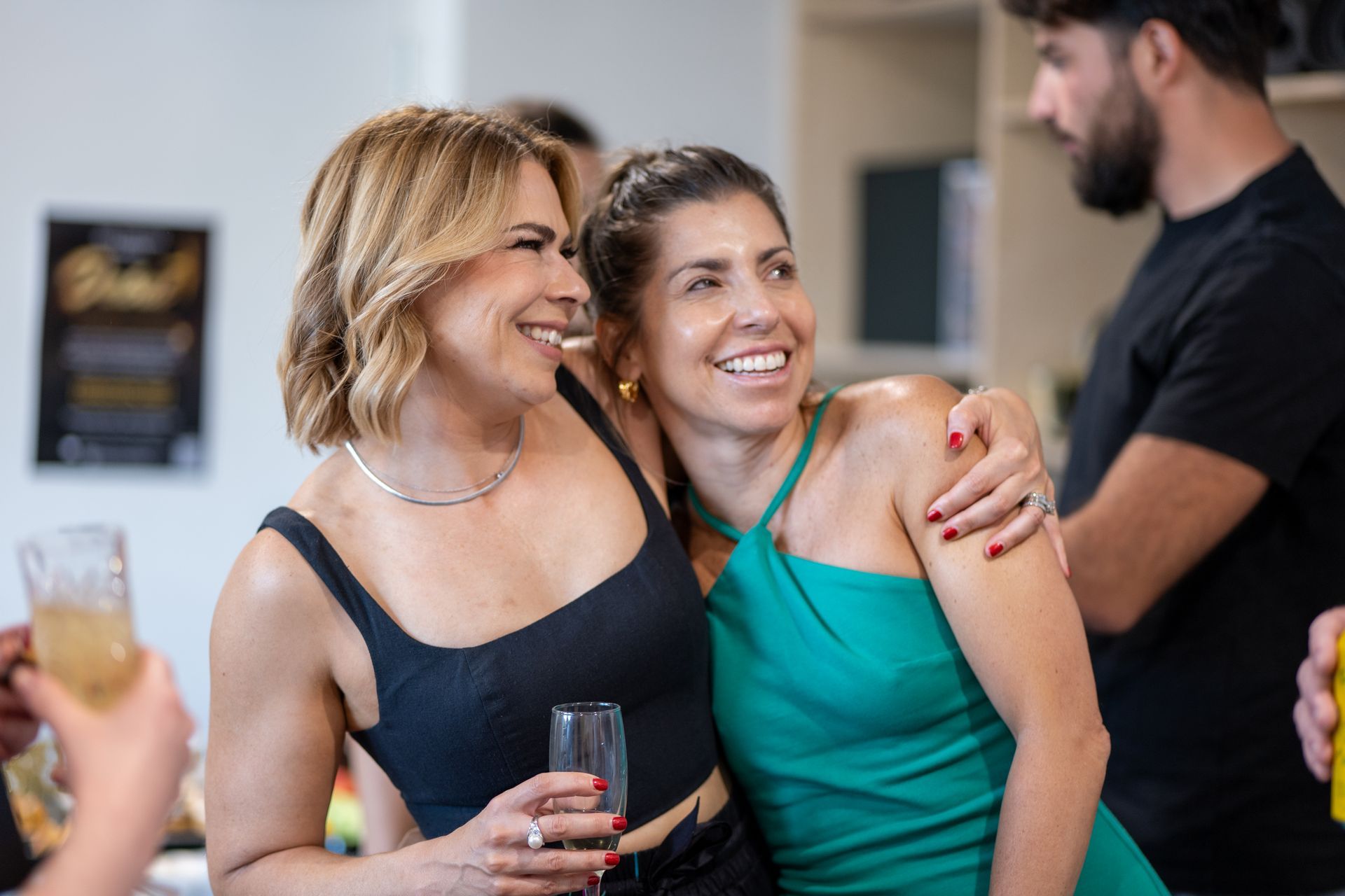 Two women are standing next to each other at a party.