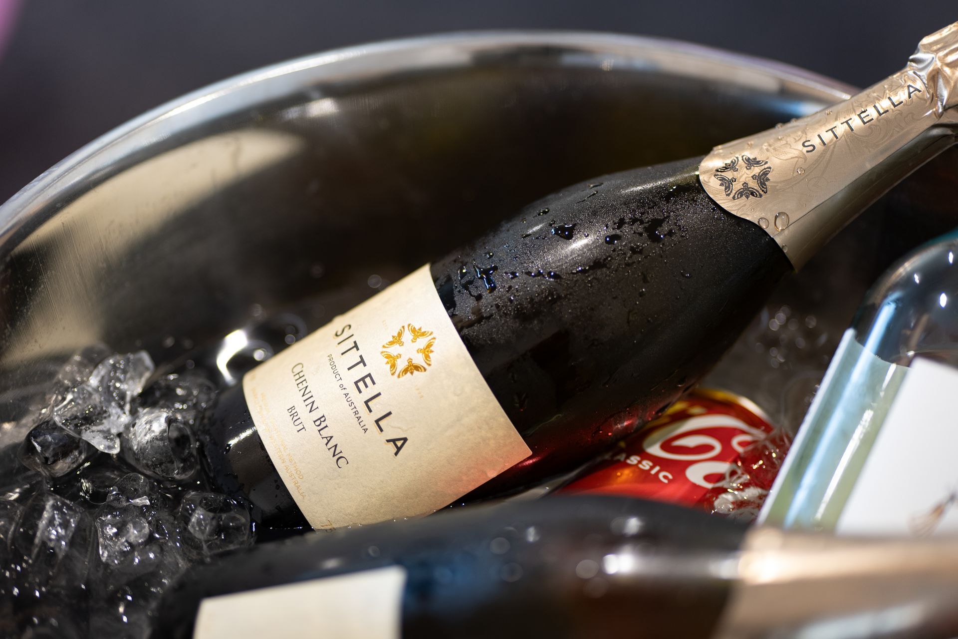 A bottle of champagne is sitting in a bucket of ice.