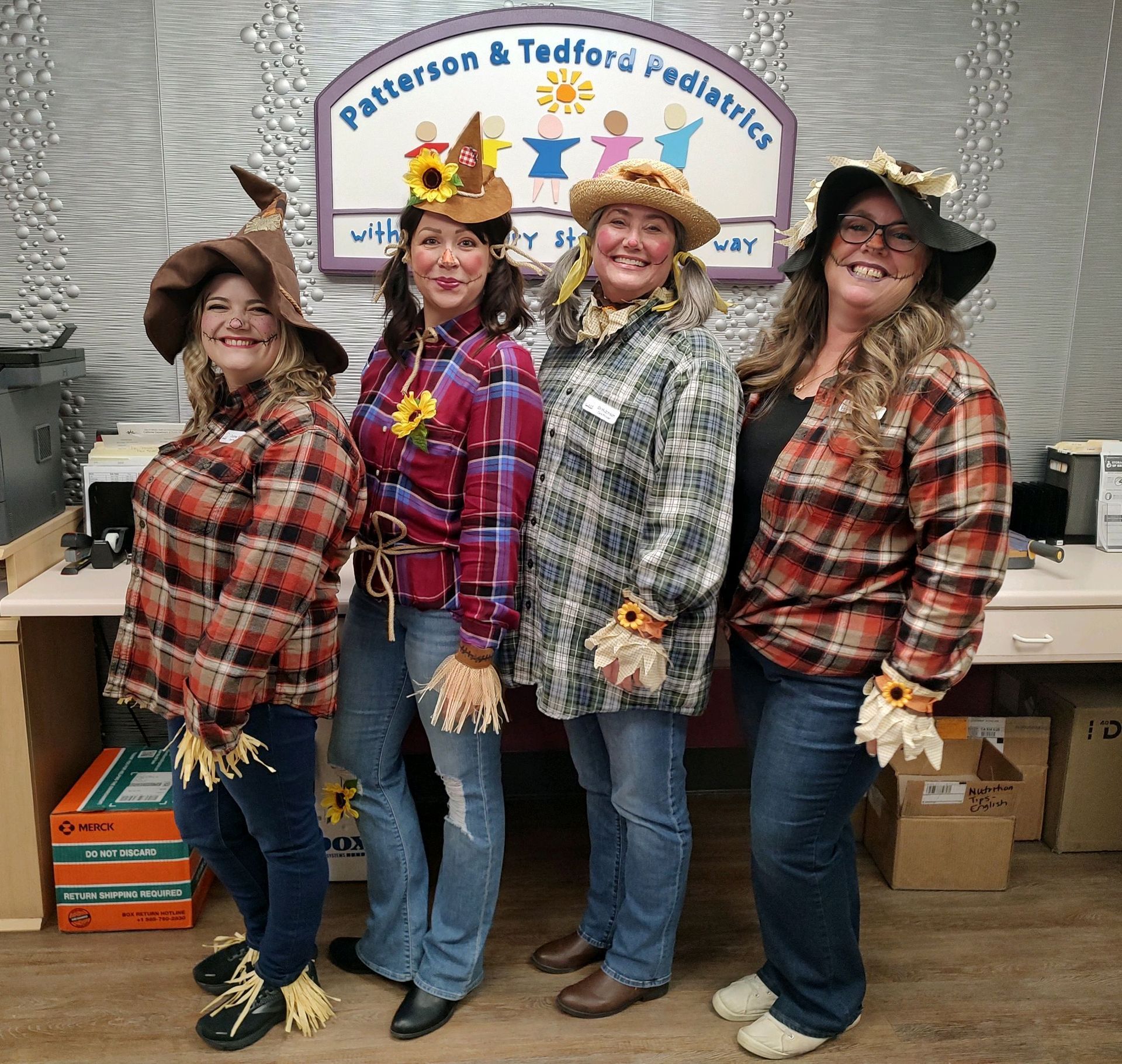 A group of women dressed in scarecrow costumes are posing for a picture.