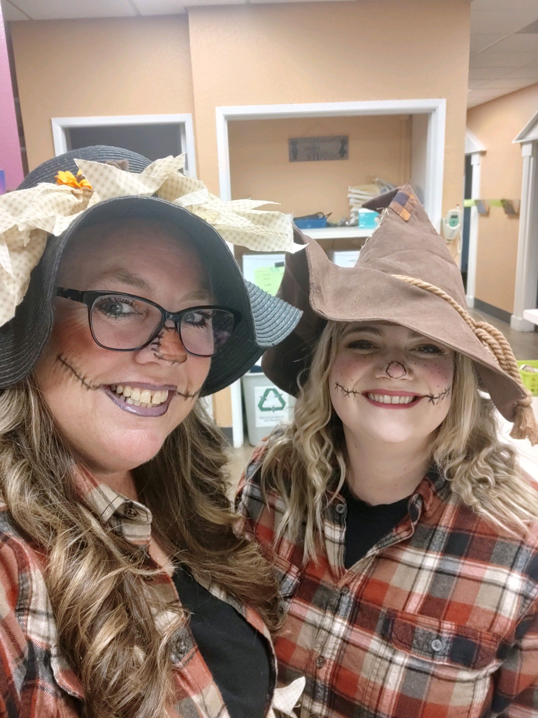 Two women dressed as scarecrows are posing for a picture.