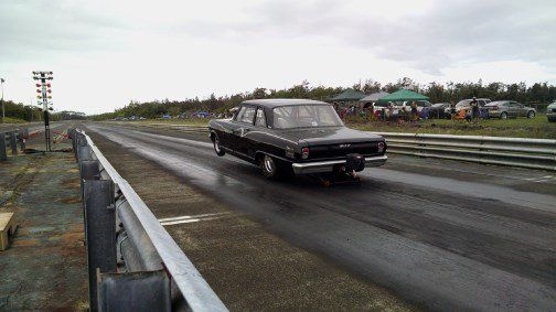 A black car is driving down a race track