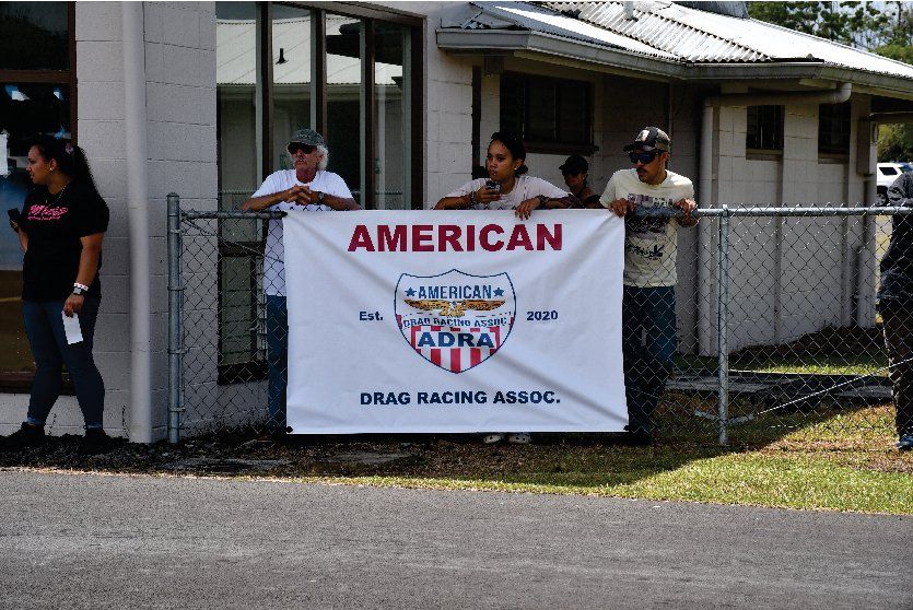 A group of people standing behind a sign that says american