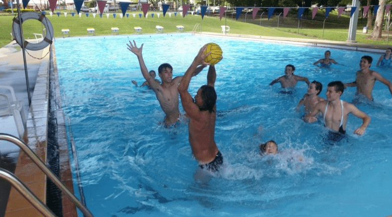 Man Passing The Ball While In Pool — Swim Training In Cannonvale, QLD