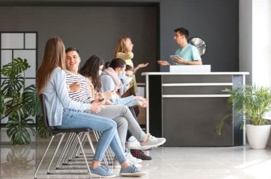 Pessoas sentadas na recepção de uma clínica de SST, demonstrando retenção de clientes
