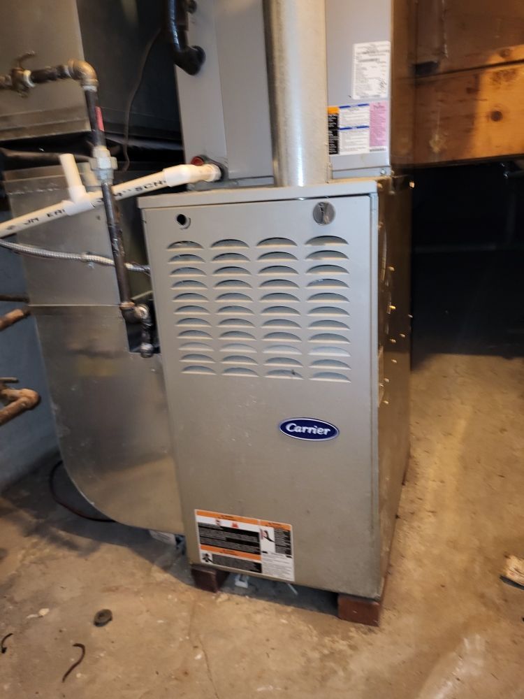 A silver Carrier furnace in a basement.