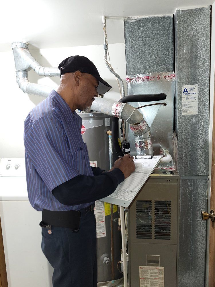 Man in uniform inspecting furnace, writing on a clipboard. Indoors, next to laundry appliances.