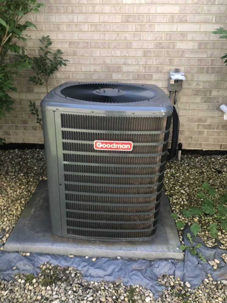 Goodman air conditioner unit outside a brick building.