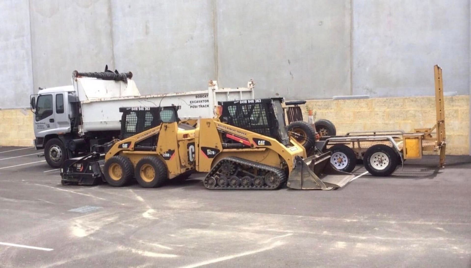 A lawn mower is sitting on top of a lush green lawn next to a wheelbarrow filled with grass.