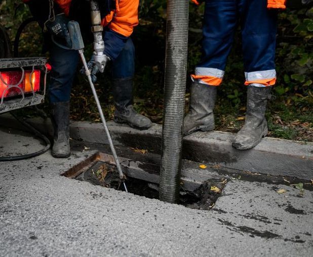 Two Men Are Working On A Drain On The Side Of The Road — All Hours Vac Truck In Lakes Creek, QLD