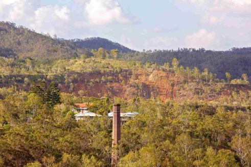 A Chimney In The Middle Of A Forest With Mountains In The Background — All Hours Vac Truck In Mt Morgan, QLD